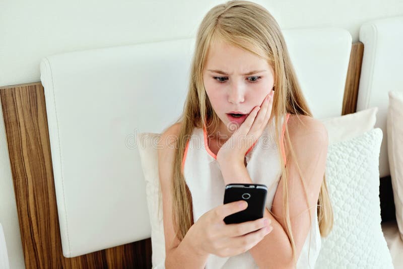Stuitende Tiener die op Bed liggen die een Mobiele Telefoon met behulp van royalty-vrije stock afbeeldingen Stuitende Tiener die op Bed liggen die een Mobiele Telefoon met behulp van royalty-vrije stock afbeeldingen