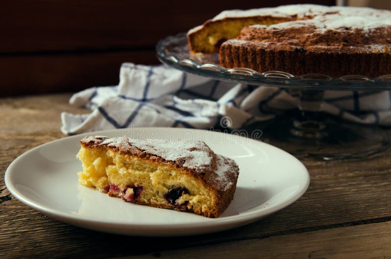 Stuk van cake met zwarte bessen en suiker royalty-vrije stock afbeelding Stuk van cake met zwarte bessen en suiker royalty-vrije stock afbeelding