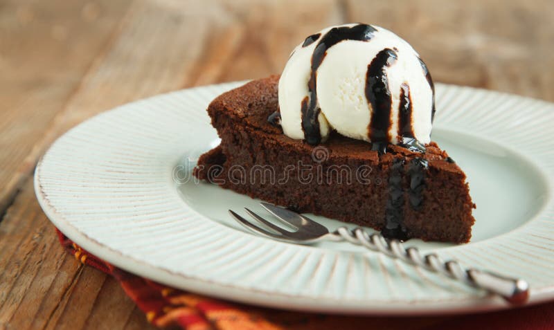 Piece of chocolate almond cornmeal cake with balsamic drizzle and ice cream. Piece of chocolate almond cornmeal cake with balsamic drizzle and ice cream