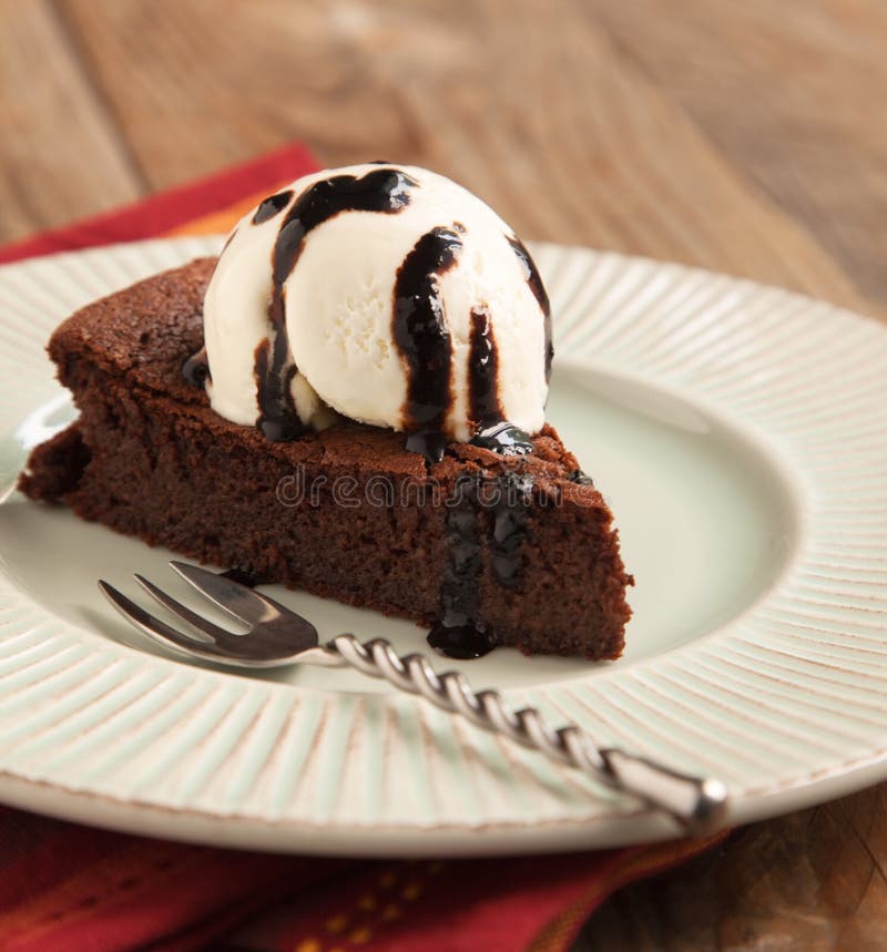 Piece of chocolate almond cornmeal cake with balsamic drizzle and ice cream. Piece of chocolate almond cornmeal cake with balsamic drizzle and ice cream