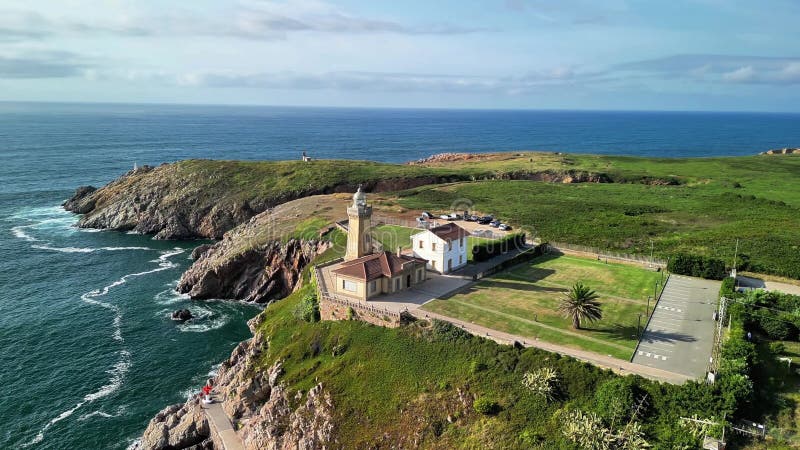A stunning coastal lighthouse surrounded by vibrant greenery and the vast ocean creates a breathtaking view. Lighthouse viewpoint stock images, royalty-free photos and pictures