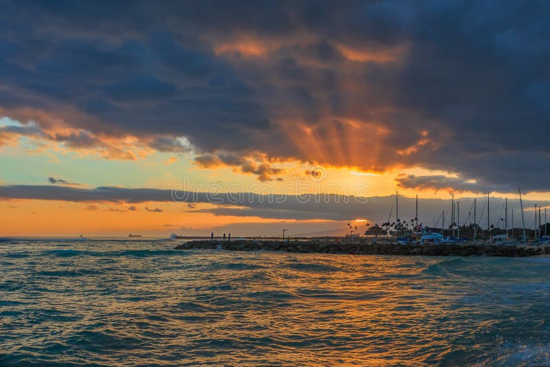 Stunning sunset with rays of sunlight shining through storm clouds in Oahu, Hawaii stock photography Stunning sunset with rays of sunlight shining through storm clouds in Oahu, Hawaii stock photography