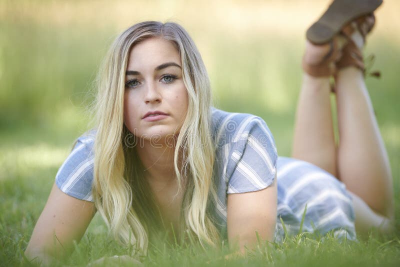 3 pretty blonde girls frolicking on the grass