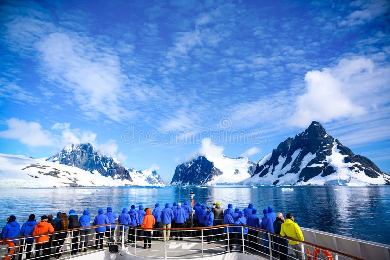 Stuntelige antarctica - toeristen met een citroenkanaal kijken naar een kanaal vol ijs tussen de bergen en het antarctische schier