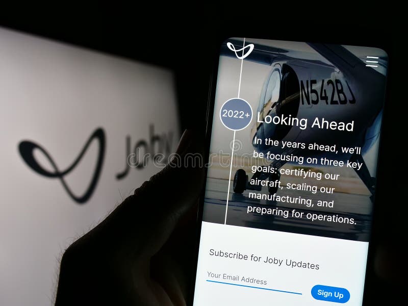 Stuttgart, Germany - 03-31-2023: Person holding cellphone with webpage of US eVTOL company Joby Aviation on screen in front of business logo. Focus on center of phone display.