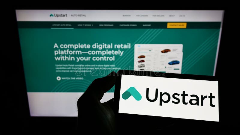 Person holding smartphone with logo of US fintech company Upstart Network Inc. on screen in front of website.