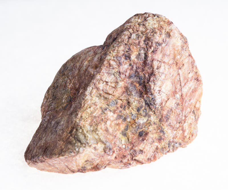 Stycke av den rosa granitstenen på vit arkivbild