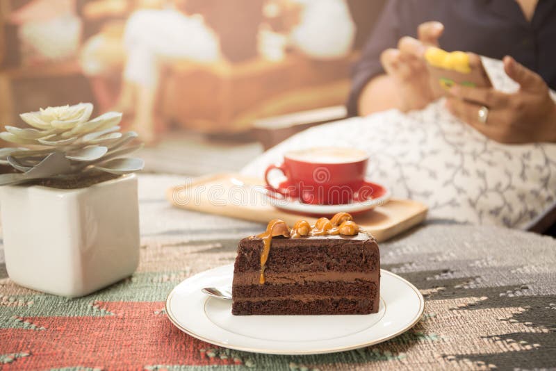 Stycke av den söta macadamiachokladkakan med koppen kaffe och s royaltyfria bilder Stycke av den söta macadamiachokladkakan med koppen kaffe och s royaltyfria bilder