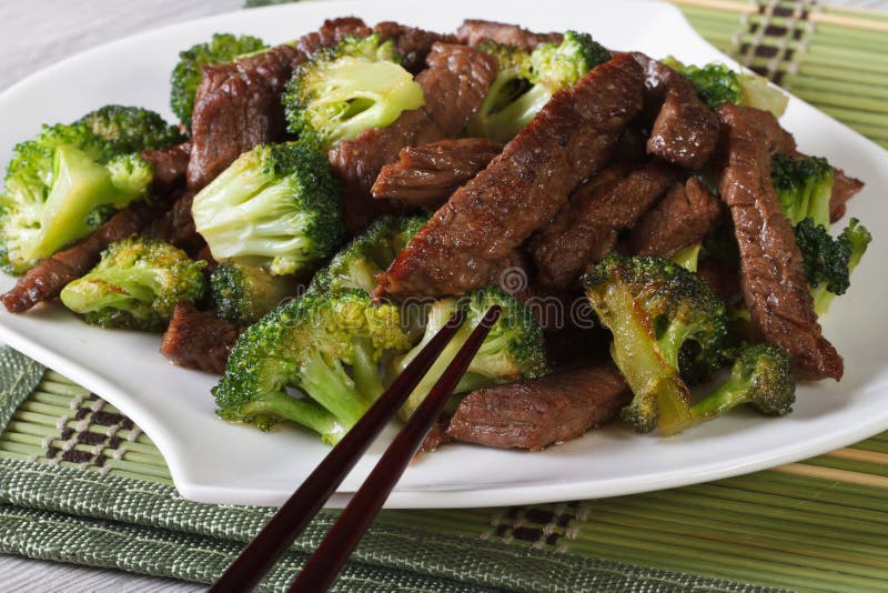 Stycken av nötkött med broccoli närbild och pinnar horisontal arkivfoto Stycken av nötkött med broccoli närbild och pinnar horisontal arkivfoto