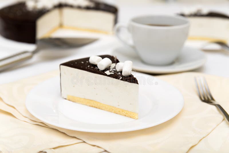 Stycket av kakan med ` s för souffle`-fågeln mjölkar `, kexet, mousse och mörkerchoklad på en vit platta royaltyfria foton Stycket av kakan med ` s för souffle`-fågeln mjölkar `, kexet, mousse och mörkerchoklad på en vit platta royaltyfria foton