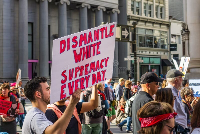 January 19, 2019 San Francisco / CA / USA - Participant to the Women`s March event holds `Dismantle white supremacy everyday` sign while marching on Market street in downtown San Francisco. January 19, 2019 San Francisco / CA / USA - Participant to the Women`s March event holds `Dismantle white supremacy everyday` sign while marching on Market street in downtown San Francisco