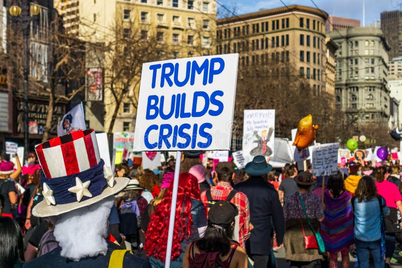 January 19, 2019 San Francisco / CA / USA - Participants to the Women`s March event holds `Trump builds crisis` sign while marching on Market street in downtown San Francisco. January 19, 2019 San Francisco / CA / USA - Participants to the Women`s March event holds `Trump builds crisis` sign while marching on Market street in downtown San Francisco