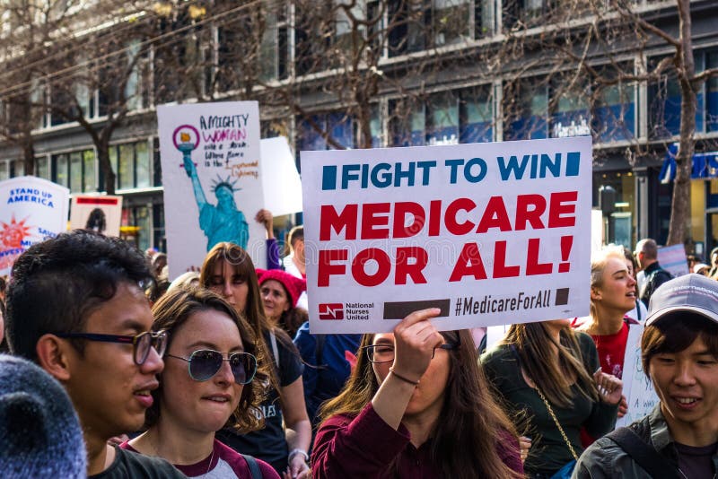 January 19, 2019 San Francisco / CA / USA - Participant to the Women`s March event holds `Medicare for all` sign while marching on Market street in downtown San Francisco. January 19, 2019 San Francisco / CA / USA - Participant to the Women`s March event holds `Medicare for all` sign while marching on Market street in downtown San Francisco