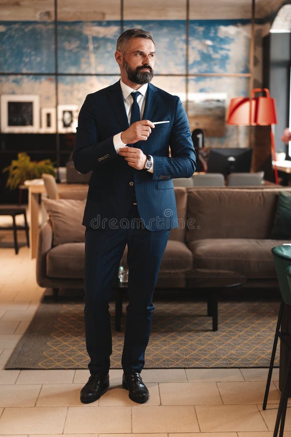 Stylish bearded man in a suit standing in modern office royalty free stock images Stylish bearded man in a suit standing in modern office royalty free stock images