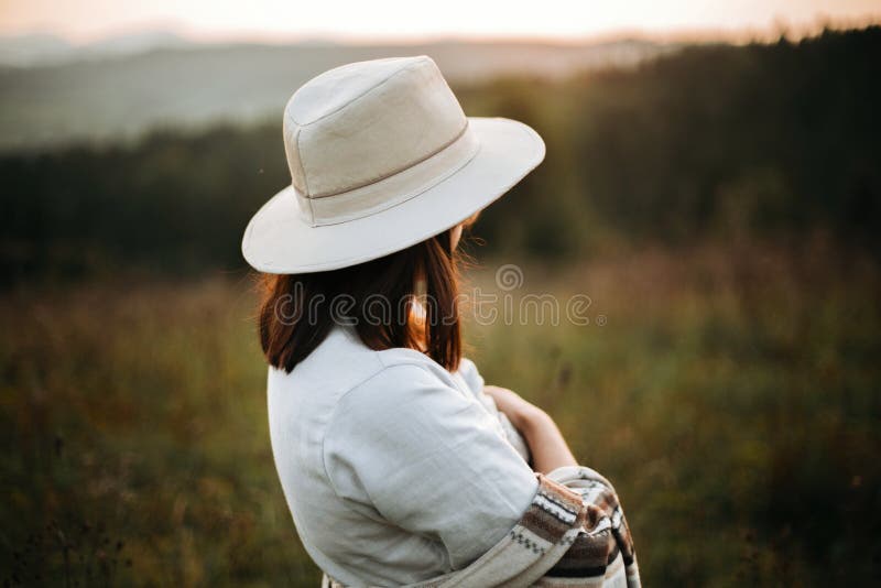 Stylish boho girl posing in sunny light at atmospheric sunset in meadow. Happy hipster woman in poncho and hat enjoying traveling royalty free stock photos Stylish boho girl posing in sunny light at atmospheric sunset in meadow. Happy hipster woman in poncho and hat enjoying traveling royalty free stock photos