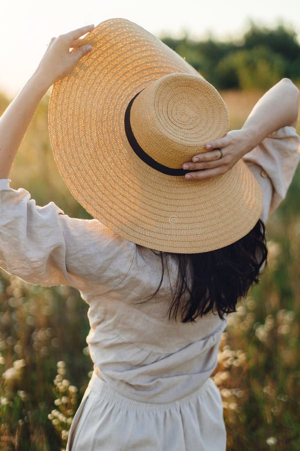 Stylish Boho Woman with Straw Hat Posing among Wildflowers in Sunset ...