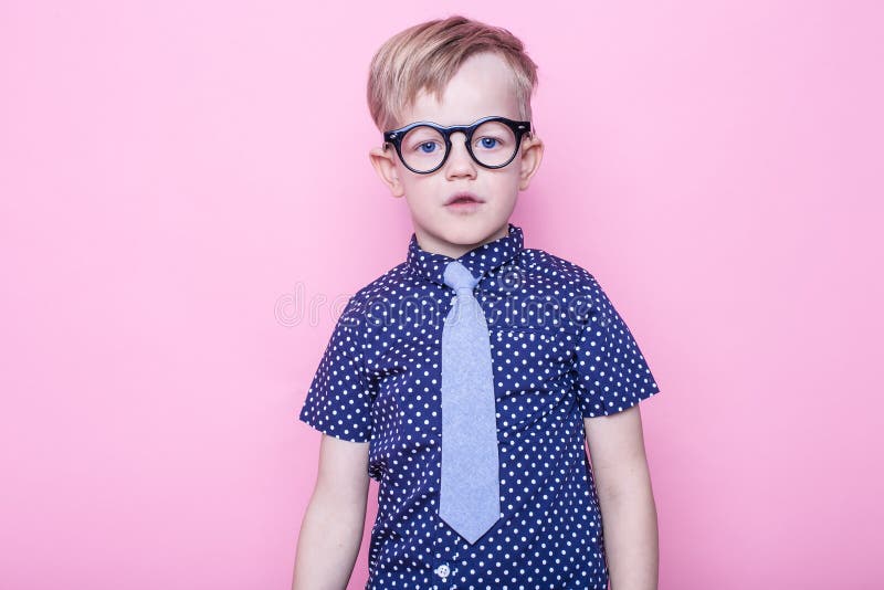 Stylish boy in shirt and glasses with big smile. School. Preschool. Fashion. Studio portrait over pink background stock image Stylish boy in shirt and glasses with big smile. School. Preschool. Fashion. Studio portrait over pink background stock image
