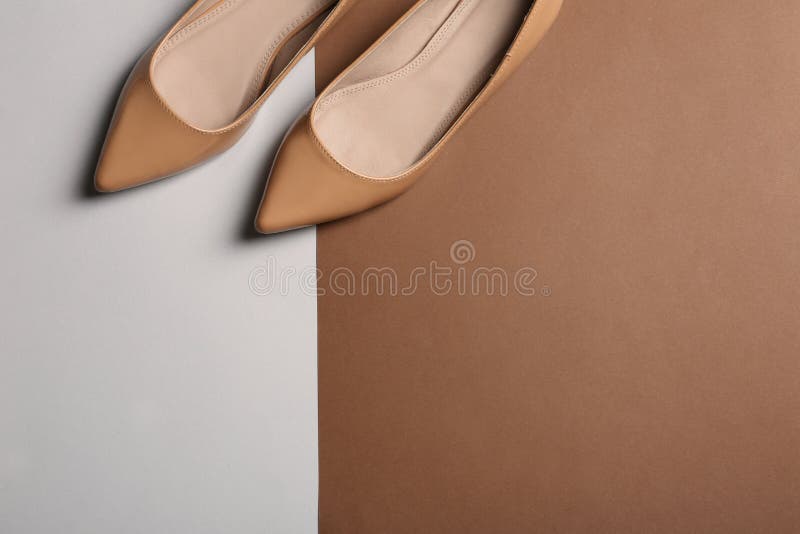 Stylish female flat shoes on color background