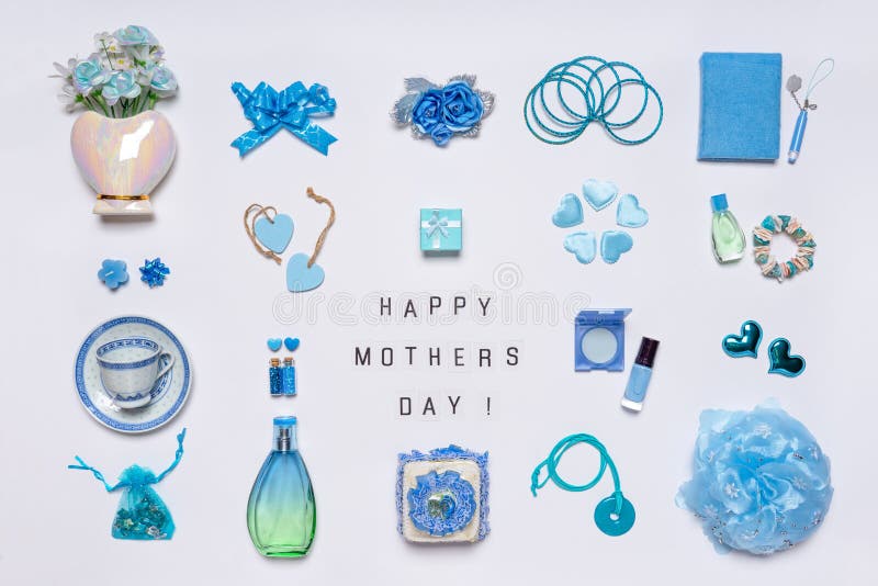 Stylish feminine accessories, flowers, cosmetics, jewelery, perfume in blue pastel colors on white background. Text HAPPY MOTHERS royalty free stock images Stylish feminine accessories, flowers, cosmetics, jewelery, perfume in blue pastel colors on white background. Text HAPPY MOTHERS royalty free stock images