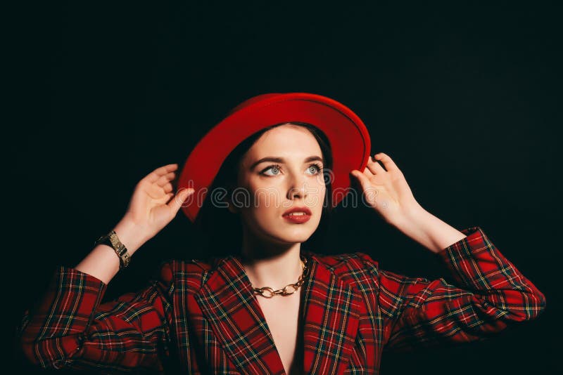 Stylish girl in red dress and hat. portrait of a young girl with long hair. Dark background stock photos Stylish girl in red dress and hat. portrait of a young girl with long hair. Dark background stock photos