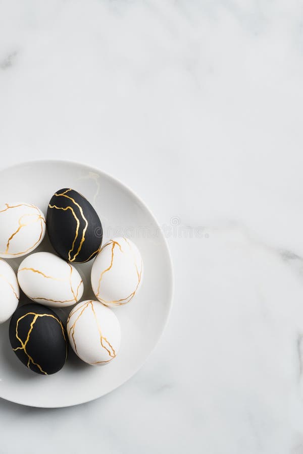 Black Easter Eggs in a Clay Plate Filled with Straw on a Grey and Blue ...