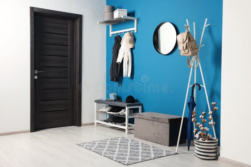 Stylish Hallway with Coat Rack and Shoe Storage Bench Near Blue Wall
