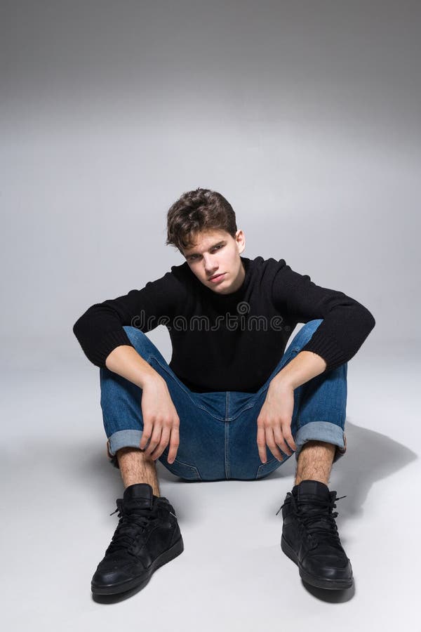 stylish handsome man posing sitting floor guy cool fashion male model grey background looking camera student 171360770