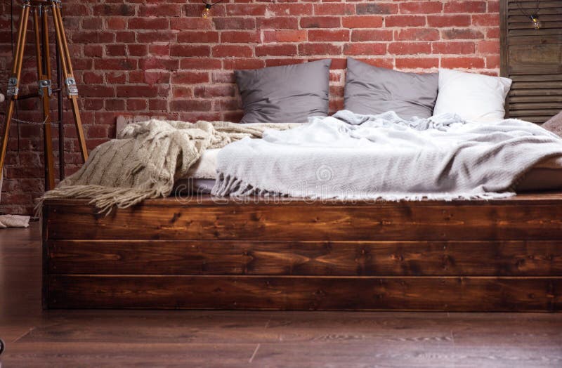 Stylish Interior Wooden Bed and the Wall Made of Brick Stock Image