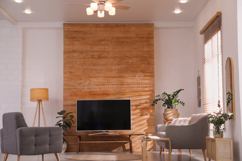 Stylish Living Room Interior with TV on Table and Houseplants Stock