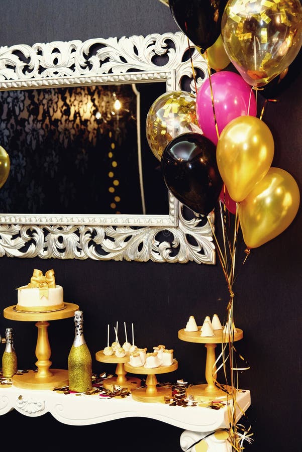 Stylish luxury decorated candy bar with frosting cake and champagne at the golden birthday party, holiday celebration concept