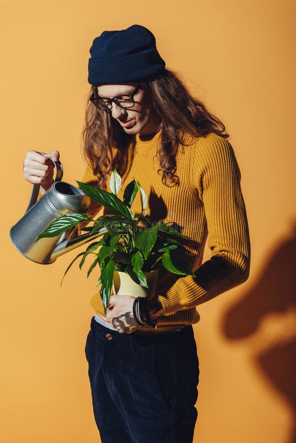 Stylish Man with Long Hair Watering Green Plant Stock Image - Image of ...