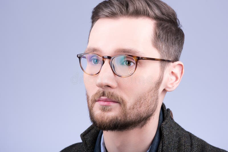 Stylish men`s glasses. Closeup portrait of young man with beard