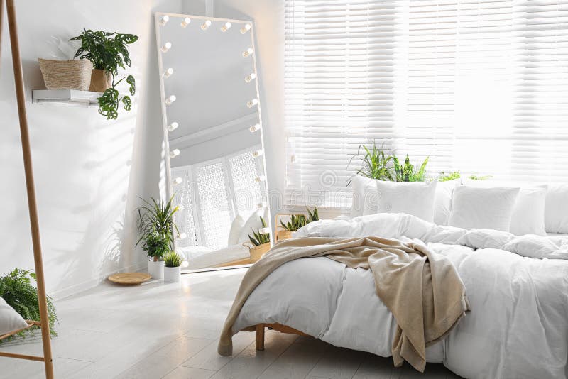 Stylish Mirror with Light Bulbs in Bedroom. Interior Design Stock Photo