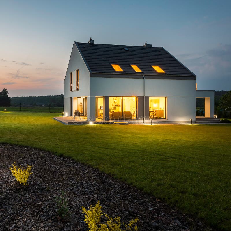 External view of stylish and modern house with outdoor lights at night. External view of stylish and modern house with outdoor lights at night
