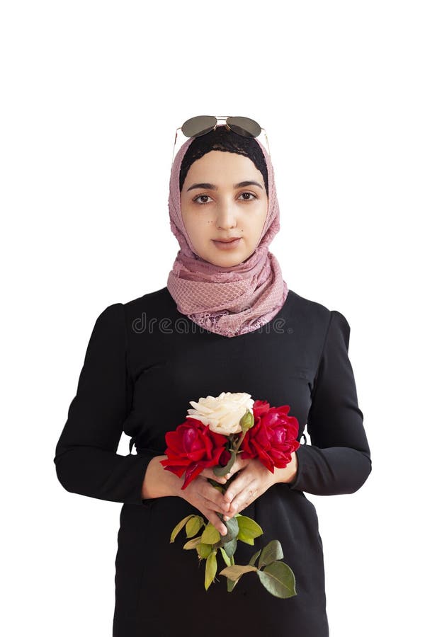 Stylish Muslim woman in traditional Islamic clothing holding flower bouquet. Portrait of beautiful middle-eastern girl in Hijab.