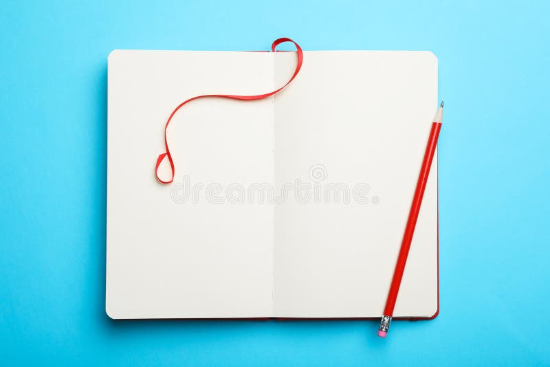 Stylish open notebook and pencil on light blue background, top view stock images