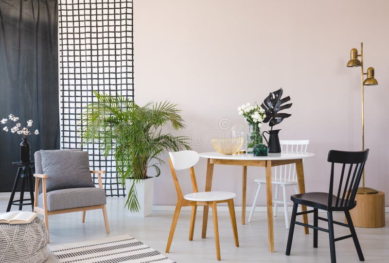 Stylish retro armchair in elegant living room interior with round dining table and black and white chairs royalty free stock photos Stylish retro armchair in elegant living room interior with round dining table and black and white chairs royalty free stock photos