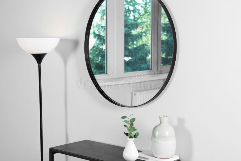 Stylish Round Mirror on White Wall Over Table in Room Stock Image