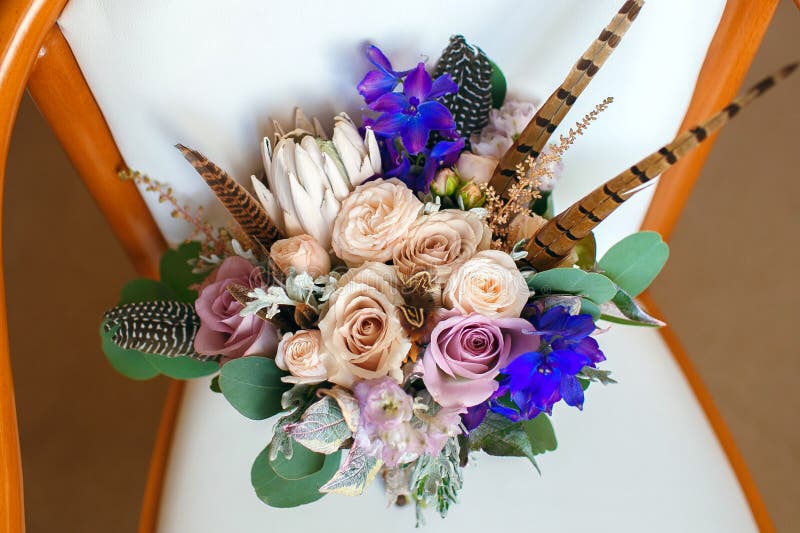 Stylish Wedding Bouquet with Feathers on a White Leather Chair Stock