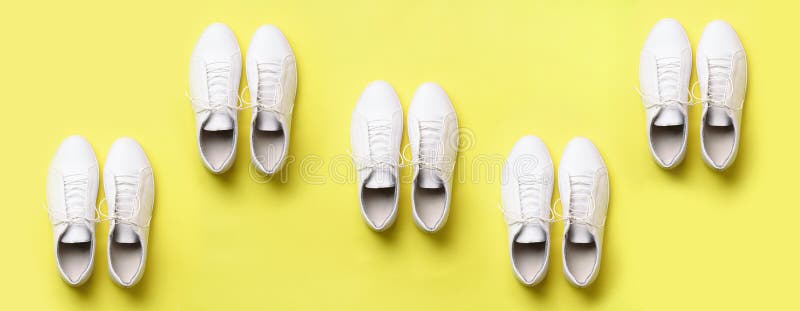 Stylish white sneakers and rope on yellow background with copy space. Top view. Minimal flat lay. Summer shoes collection. First s