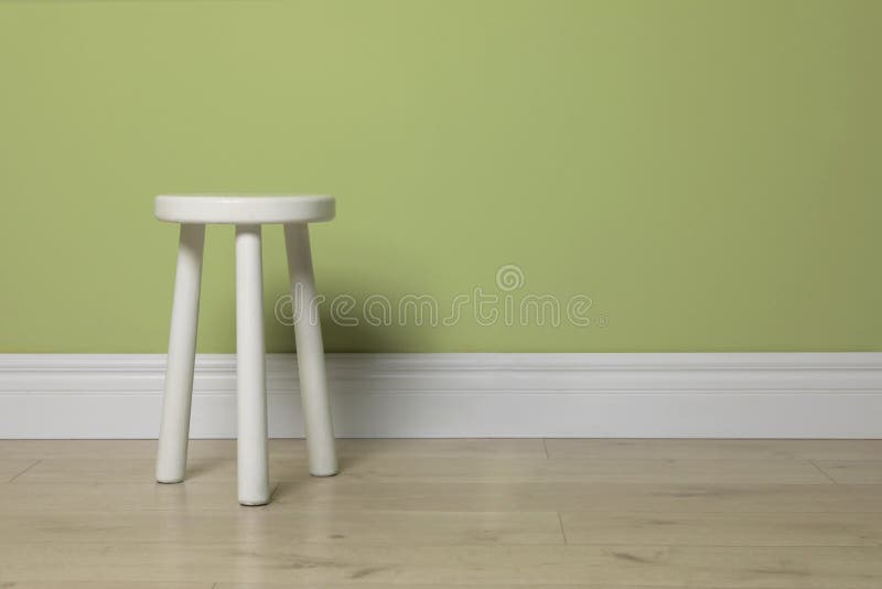 Stylish White Stool Near Light Green Wall Indoors. Space for Text Stock