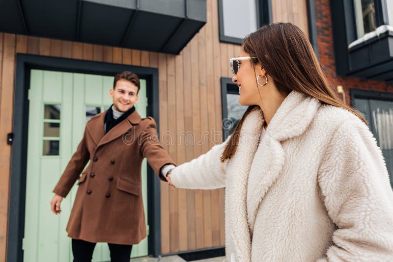 Stylish wife wearing warm beige coat asking her man to go for a walk royalty free stock photo Stylish wife wearing warm beige coat asking her man to go for a walk royalty free stock photo