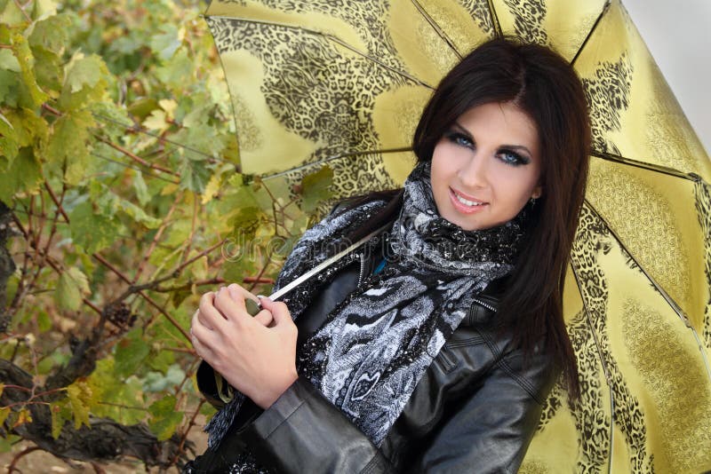 Stylish young girl with green umbrella