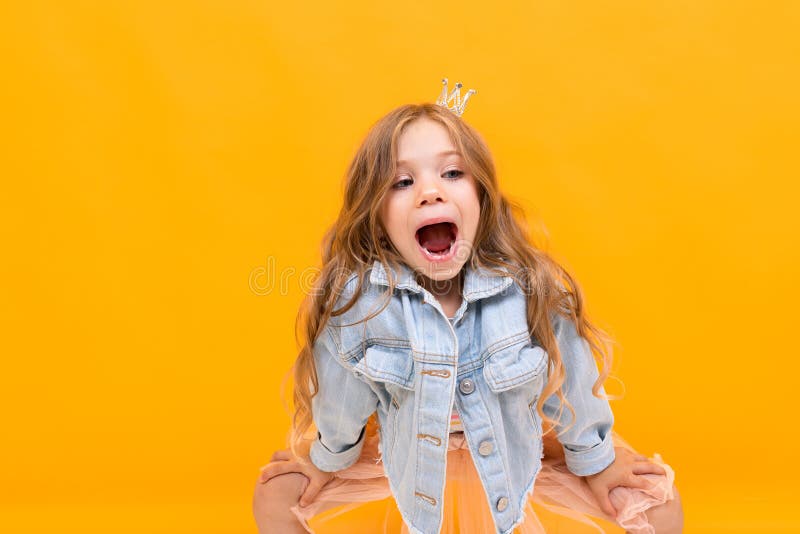 Stylish young girl posing  on a yellow studio background