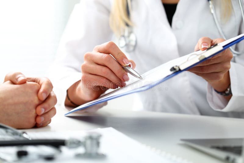 Stylo femelle d'argent de prise de main de docteur remplissant liste d'histoire patiente photographie stock libre de droits Stylo femelle d'argent de prise de main de docteur remplissant liste d'histoire patiente photographie stock libre de droits