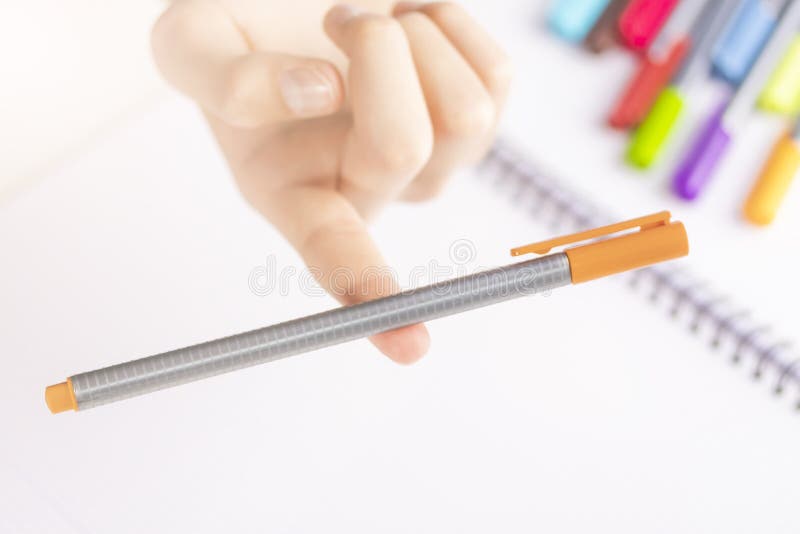 Stylo feutre orange dans l'équilibre sur le doigt d'un enfant image stock Stylo feutre orange dans l'équilibre sur le doigt d'un enfant image stock
