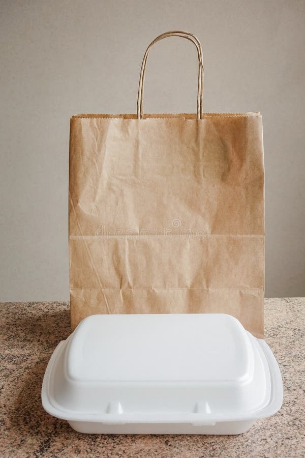 Styrofoam Food Box and a Paper Bag on the Kitchen Table Stock Image