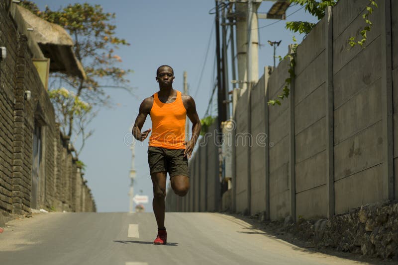 Städtische Runner-Workout. Junge attraktive und sportliche schwarz nach amerikanischem Mann im Freien auf Asphalt Straße Trainin lizenzfreies stockbild Städtische Runner-Workout. Junge attraktive und sportliche schwarz nach amerikanischem Mann im Freien auf Asphalt Straße Trainin lizenzfreies stockbild