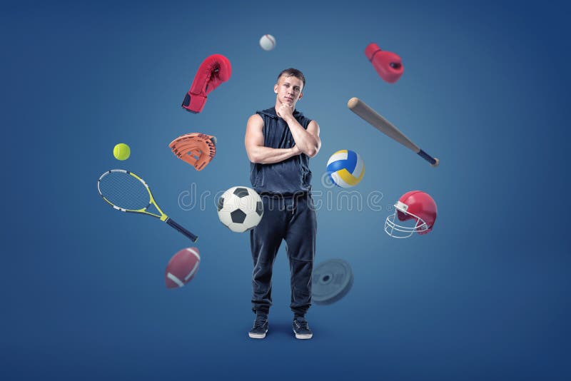 Stände eines übersetzen die durchdachten muskulösen Mannes, die durch unterschiedlichen Sport umgeben werden, Fliegen um ihn lizenzfreie stockbilder Stände eines übersetzen die durchdachten muskulösen Mannes, die durch unterschiedlichen Sport umgeben werden, Fliegen um ihn lizenzfreie stockbilder