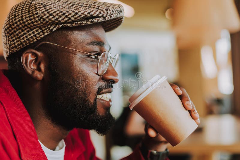 Stäng sig upp av den skäggiga mannen som ler och dricker kaffe fotografering för bildbyråer Stäng sig upp av den skäggiga mannen som ler och dricker kaffe fotografering för bildbyråer